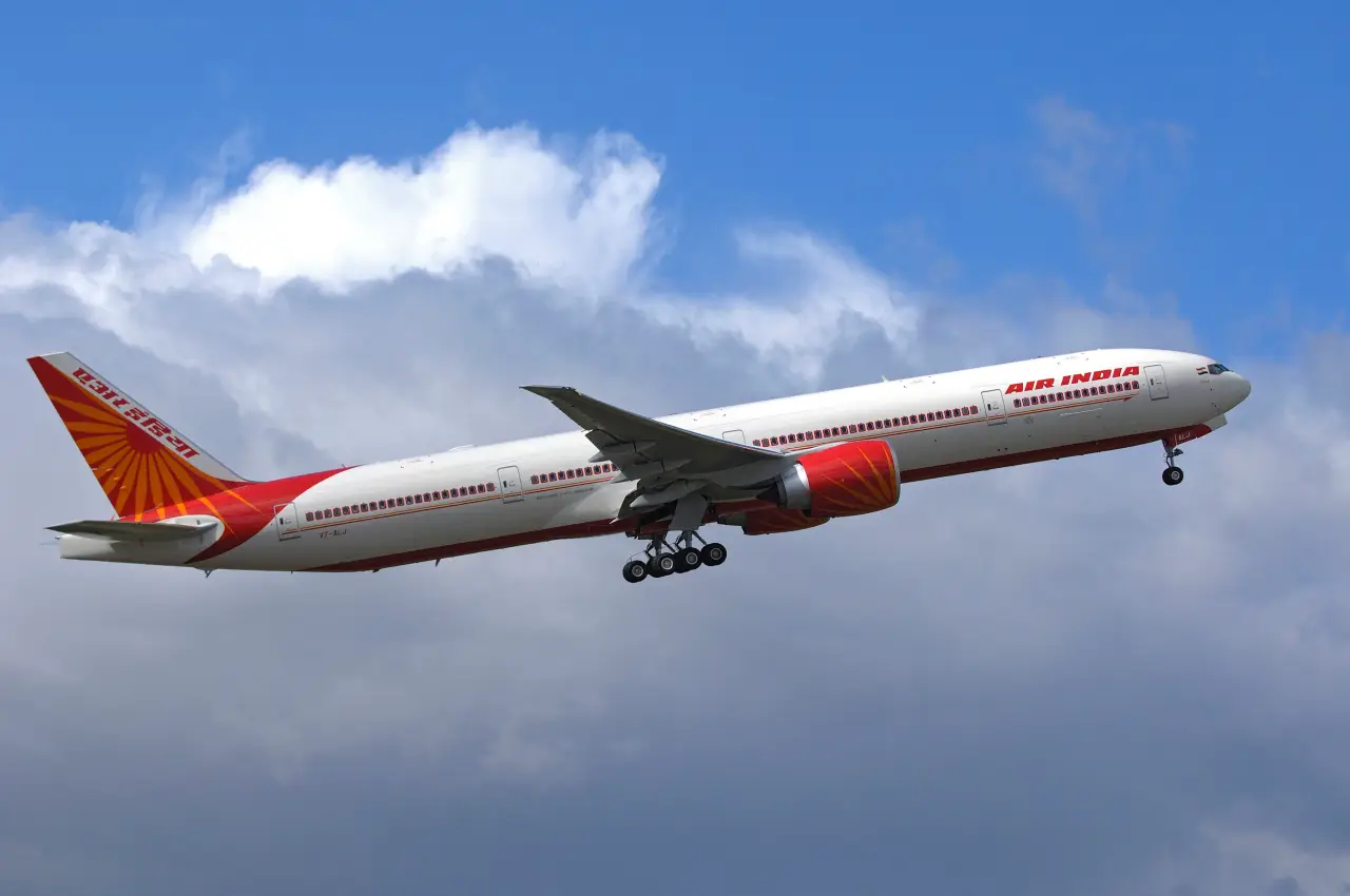 Air India Boeing 777 aircraft in flight against blue sky, similar model used on Delhi to Vancouver route affected by aircraft variant issue