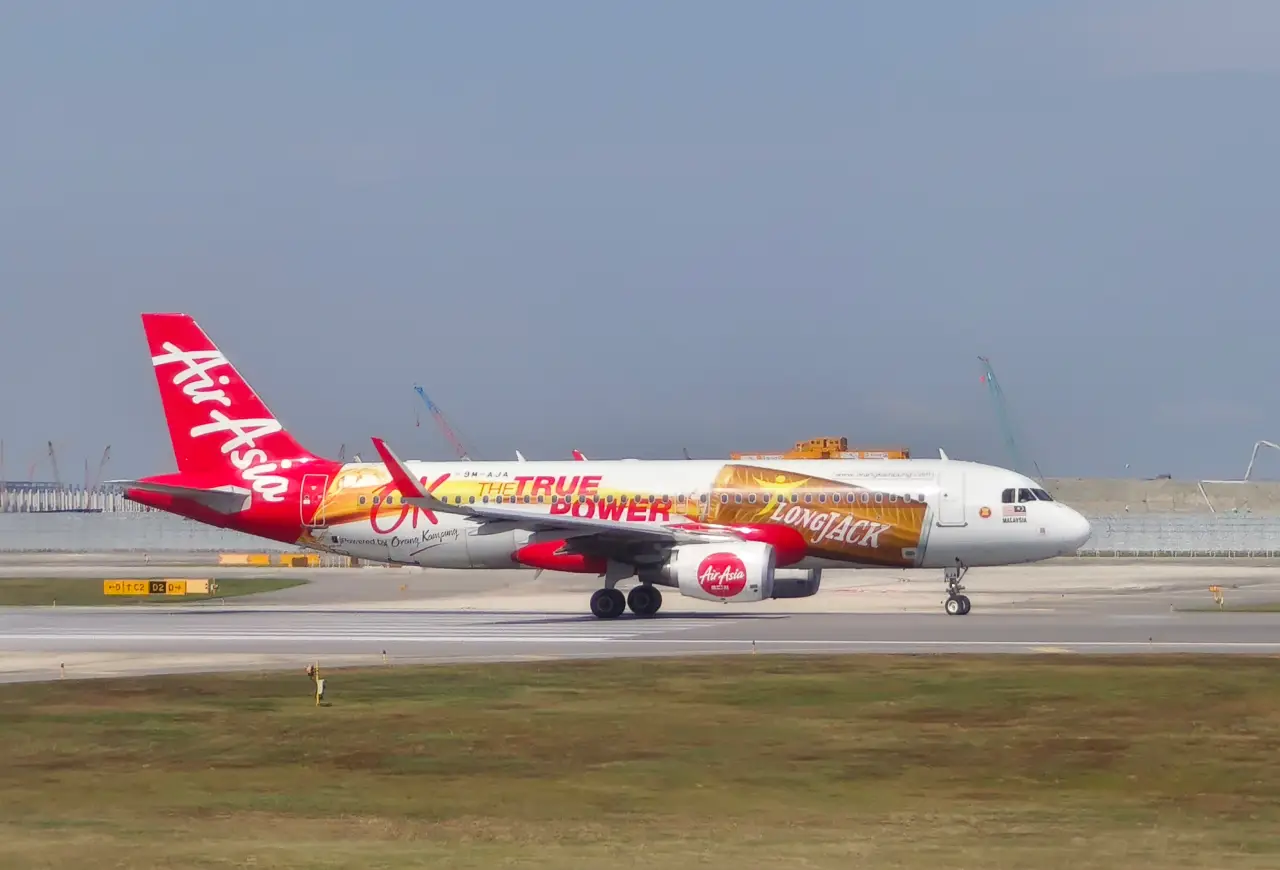 AirAsia Airbus A320 aircraft taxiing on runway at an airport