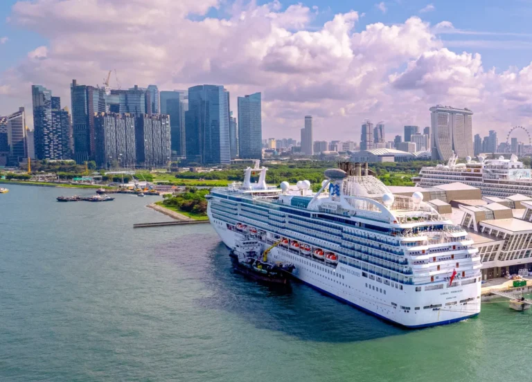 Cruise Travel 30 Coral Princess cruise ship docked at Marina Bay Cruise Centre with Singapore skyline and Marina Bay Sands in the background