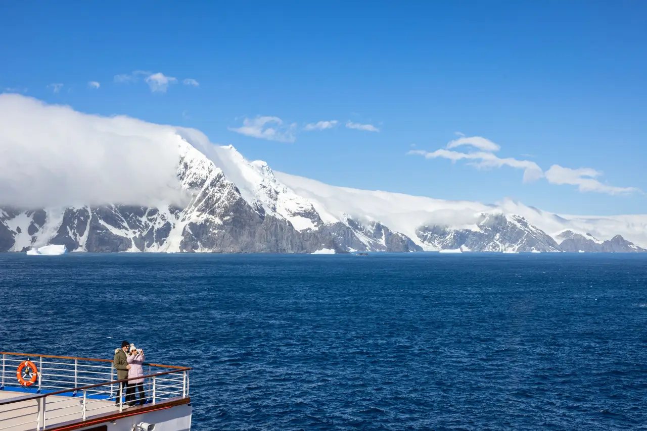 Princess Cruises Announces 2027-28 South America Season : Explore 19 Destinations, 15 Unesco Sites, And Antarctica 3 Cruise passengers viewing snow-covered mountains and icy coastline near Elephant Island in Antarctica
