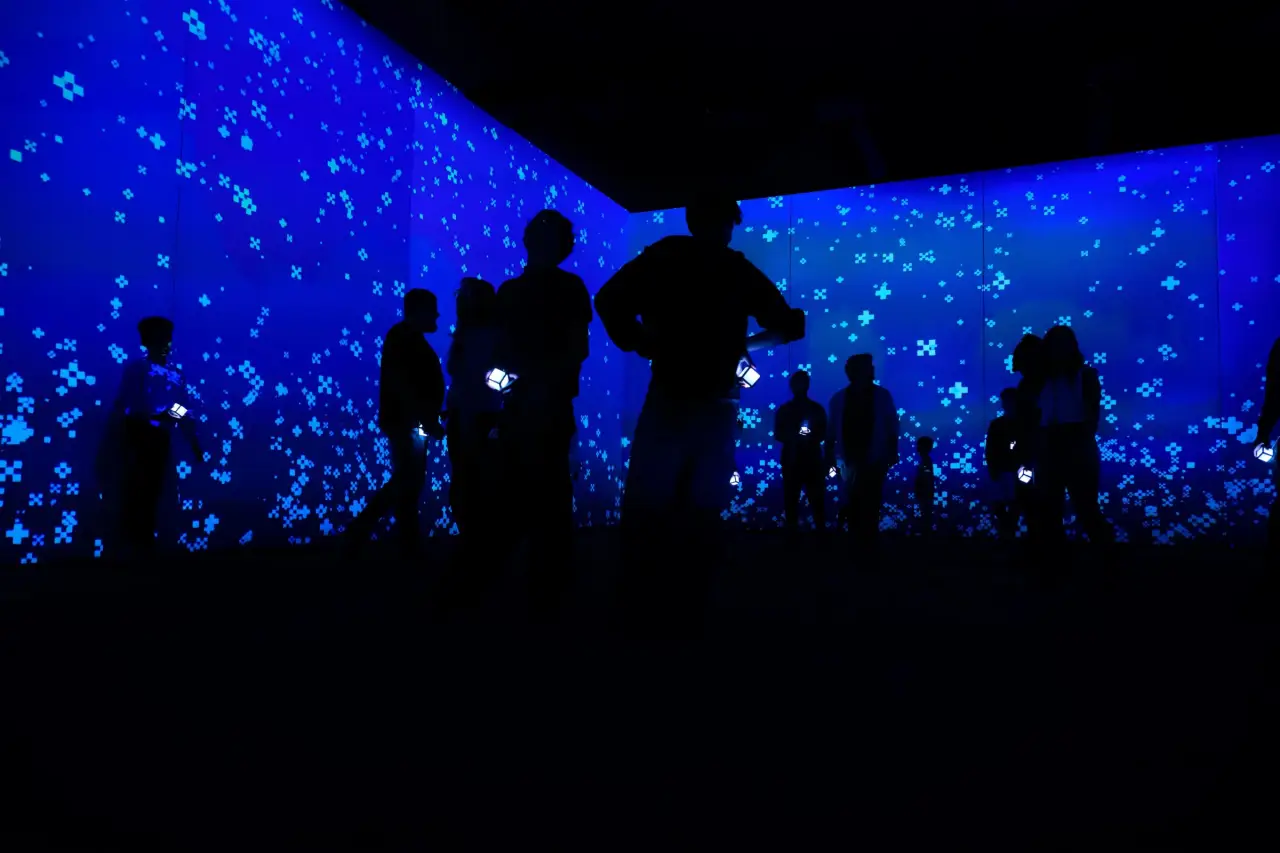 Zombie Attack: Minecraft Experience To Make Its First Stop In Asia In Singapore 3 Visitors walk through a glowing blue Minecraft biome room during the immersive Minecraft Experience: Villager Rescue attraction in Singapore.