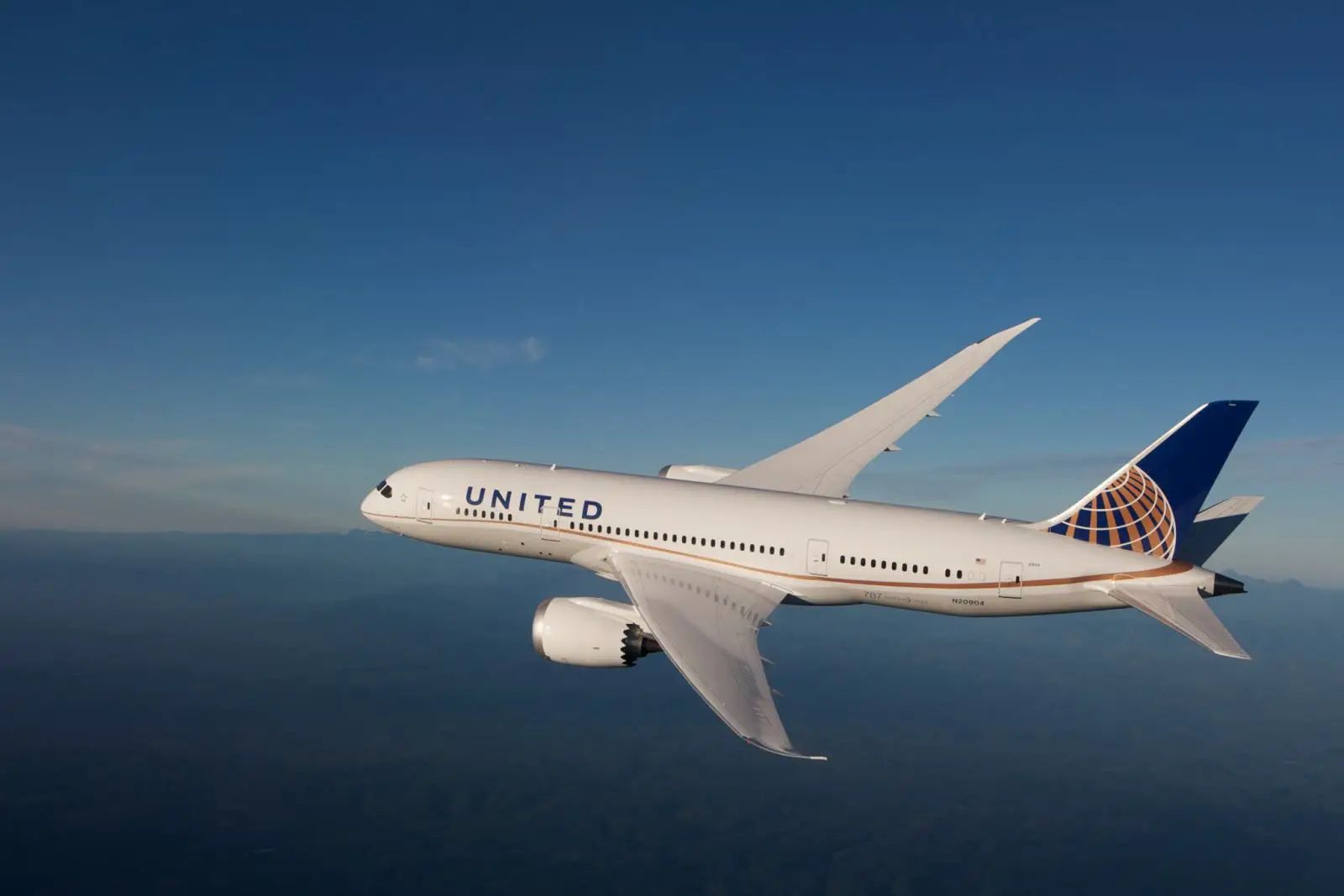 United Airlines Boeing 787-9 Dreamliner flying in clear blue skies during a long-haul flight