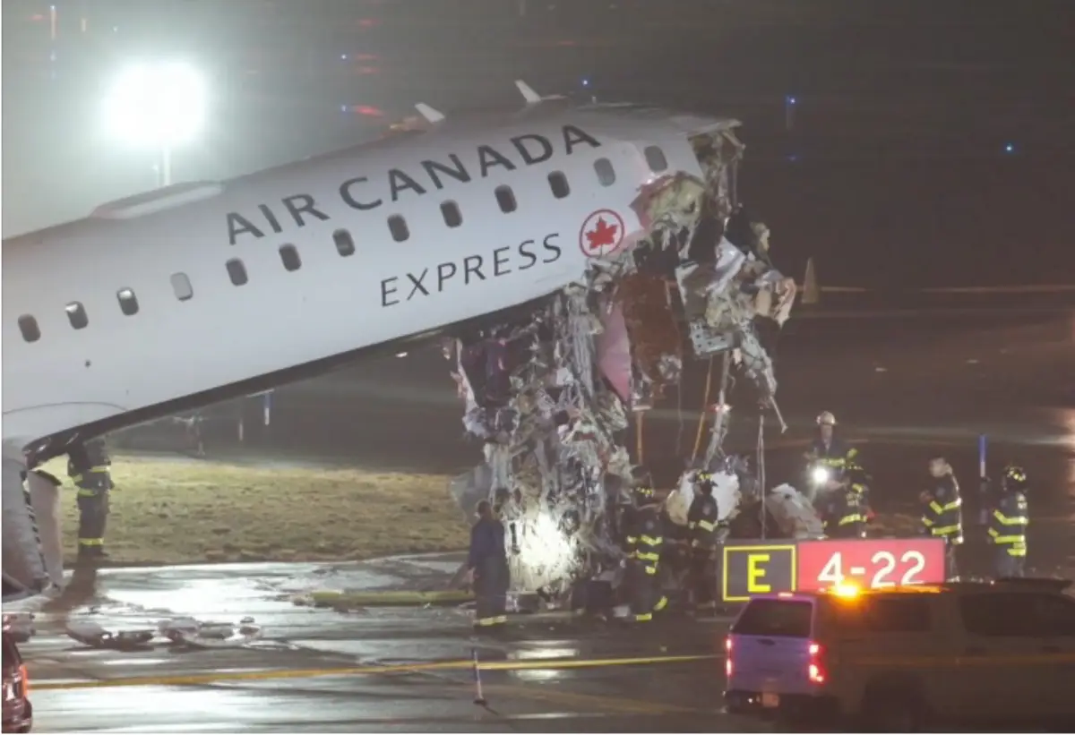 Air Canada Express CRJ-900 aircraft with severe nose damage on runway at LaGuardia Airport after collision with ground vehicle at night