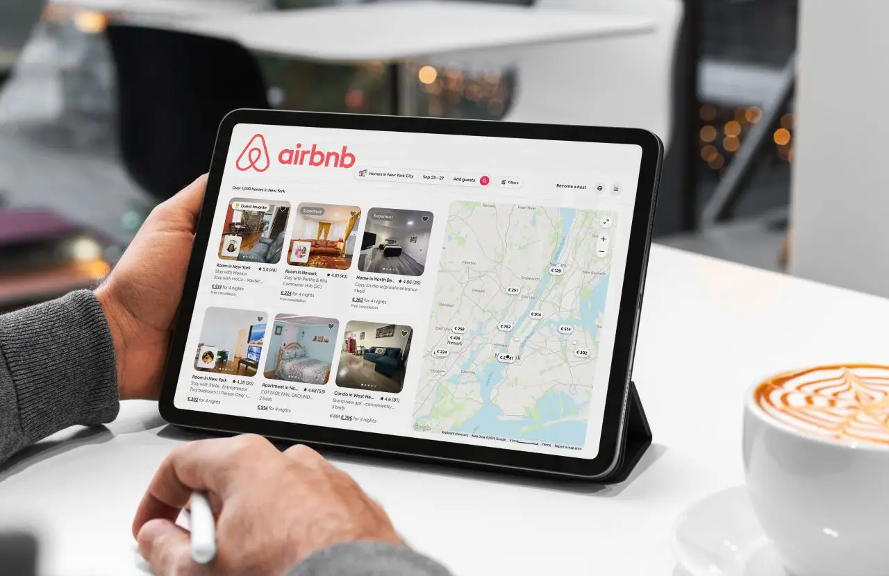 Traveller browsing Airbnb listings on a tablet while planning accommodation for a trip