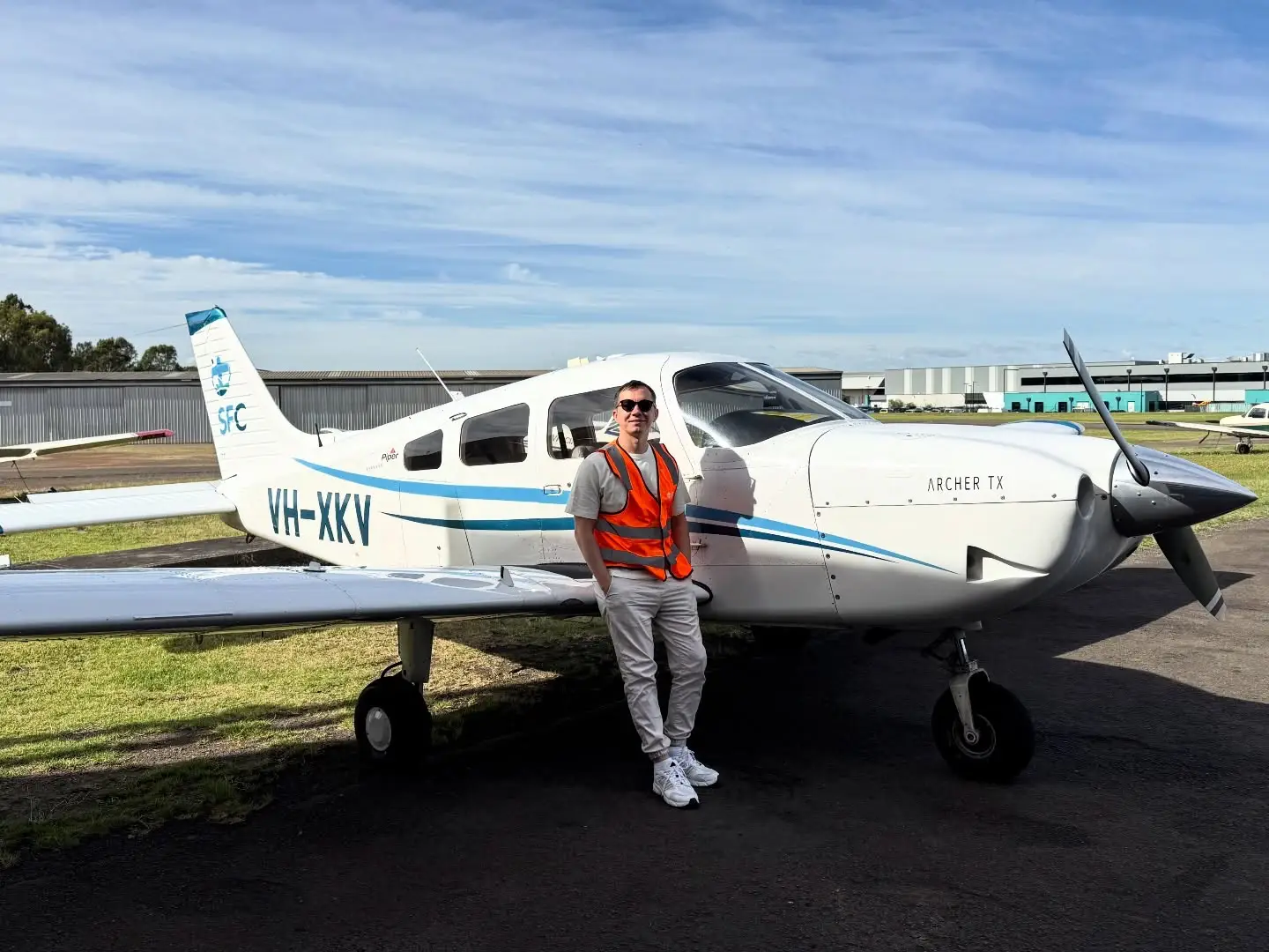 Small private aircraft on runway with aviation blogger Pavel Koshkin standing beside plane before flight