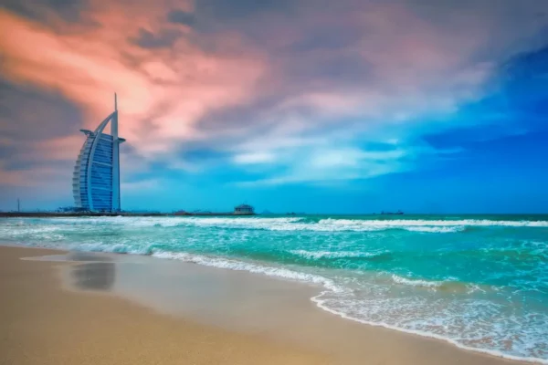 Burj Al Arab hotel and Jumeirah Beach in Dubai with turquoise sea and dramatic sunset sky