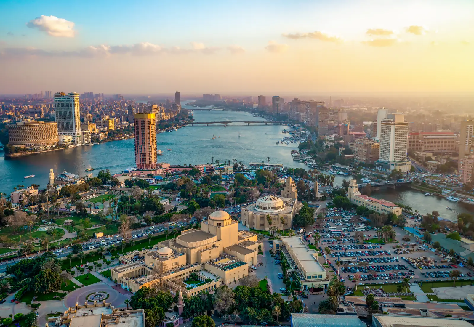 Panoramic view of Cairo skyline and Nile River at sunset with city landmarks and bridges