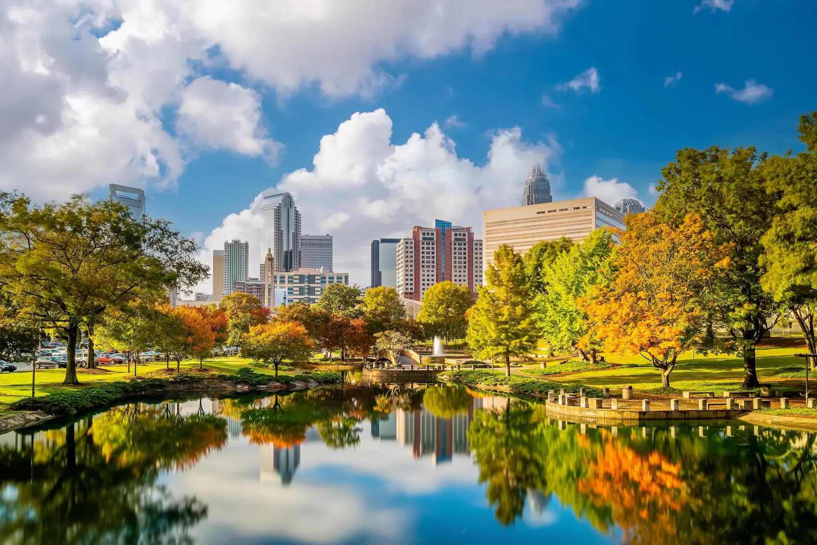 Charlotte skyline reflected in park lake with autumn trees, North Carolina