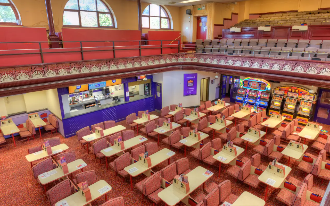 Historic Judges Bingo Hall interior in Tonypandy, Wales with rows of bingo tables, balcony seating and arcade machines