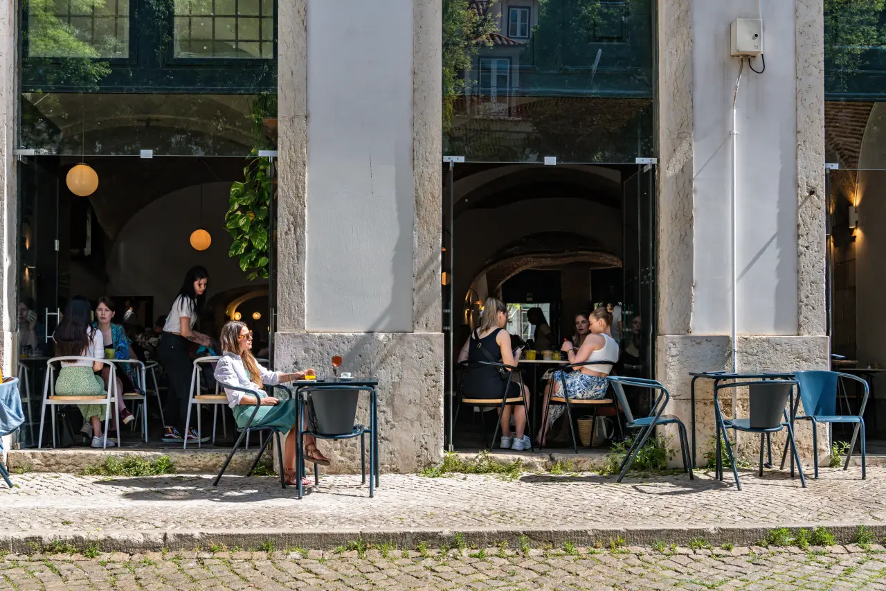 Woman enjoying lunch alone at a sunny outdoor café in Lisbon, Portugal