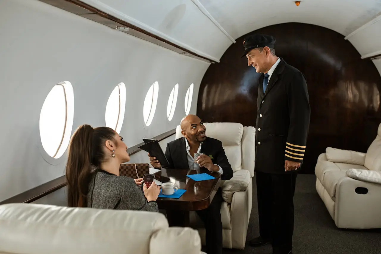 Private jet passengers speaking with pilot inside luxury aircraft cabin during flight