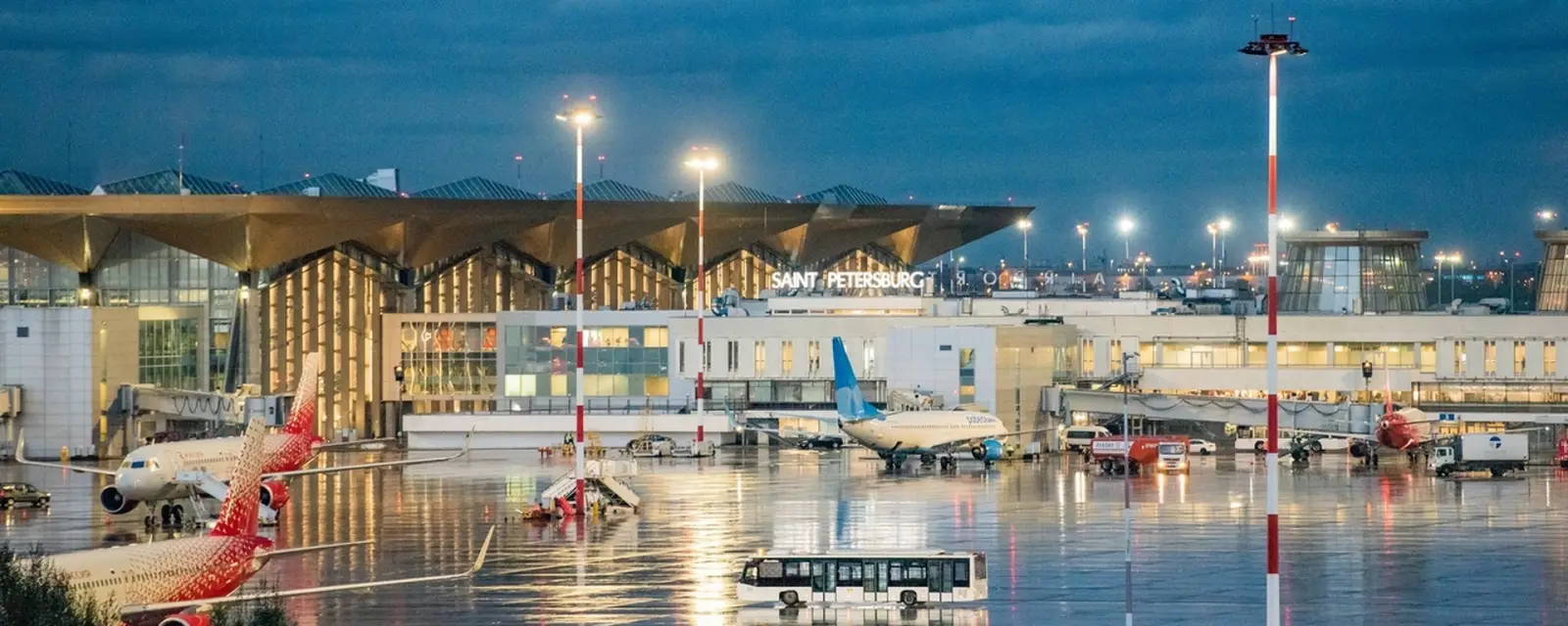 Pulkovo Airport in St Petersburg at night with aircraft on apron and terminal illuminated after major flight disruptions