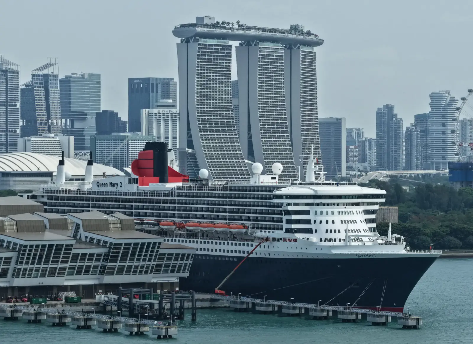 Queen Mary 2 docked in Singapore with Marina Bay Sands skyline in the background