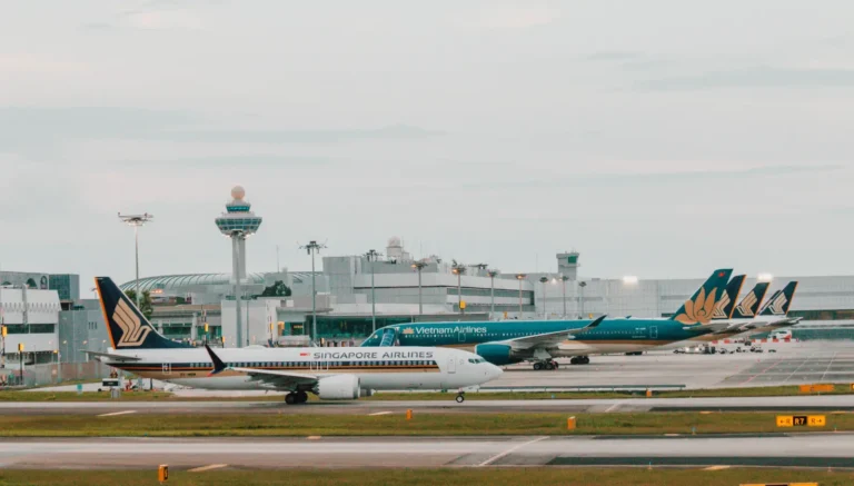 Singapore Airlines aircraft taxiing at Changi Airport with Vietnam Airlines planes in the background