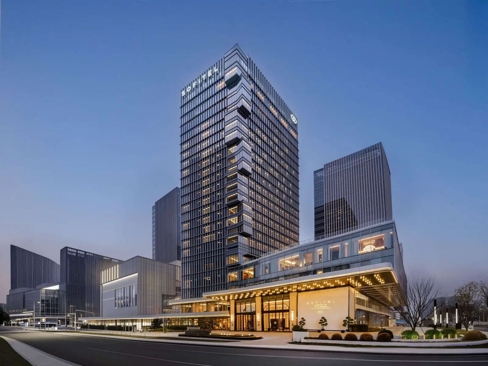 Sofitel Changzhou Hi-Tech District hotel exterior at dusk with illuminated tower and modern business district skyline