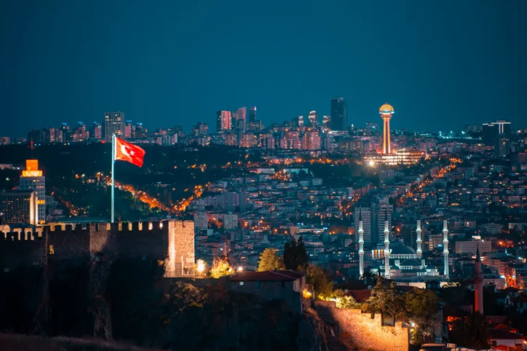 Ankara skyline at twilight with Ankara Castle, Turkish flag and Atakule Tower illuminated at night