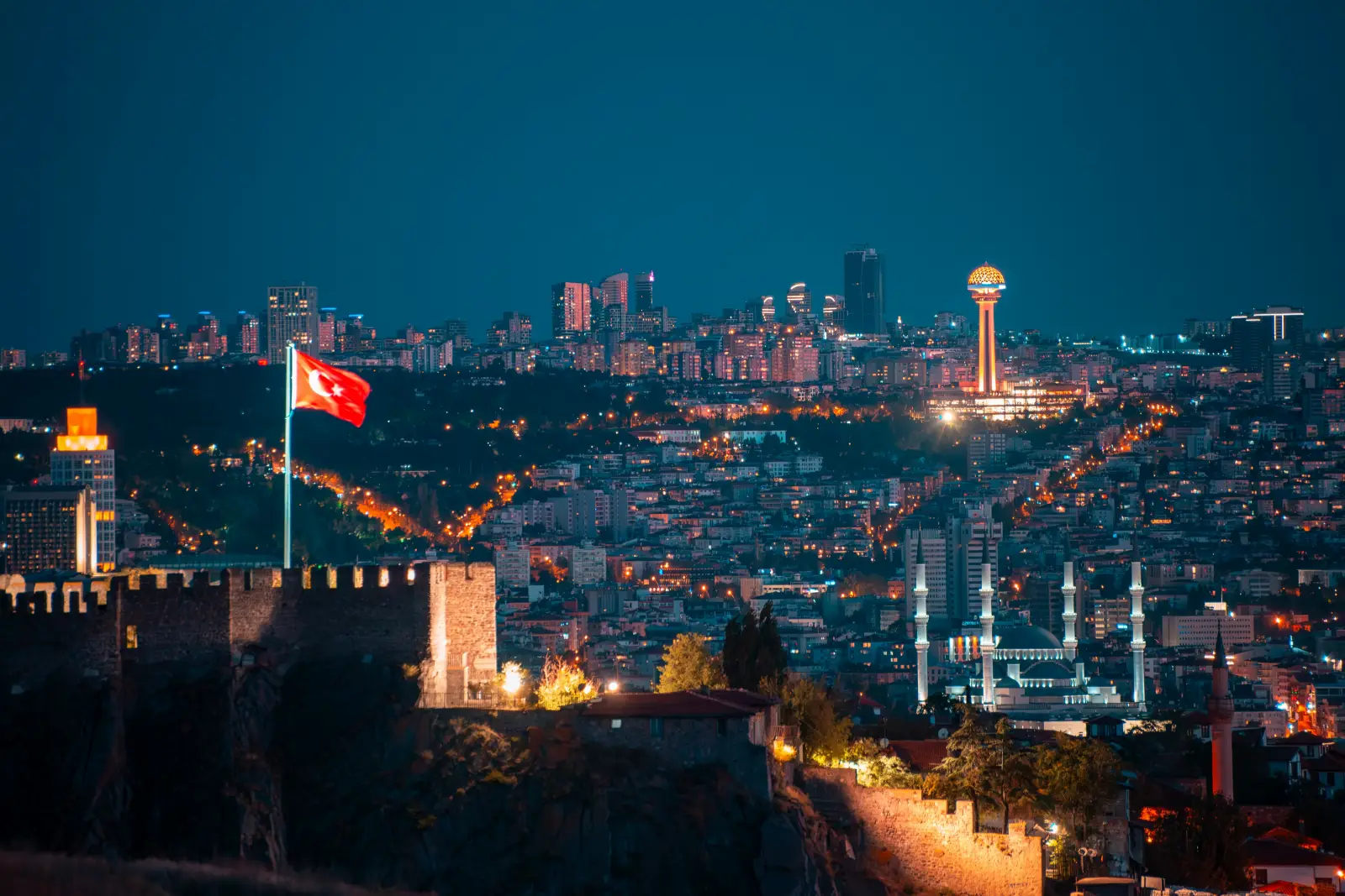 Ankara skyline at twilight with Ankara Castle, Turkish flag and Atakule Tower illuminated at night