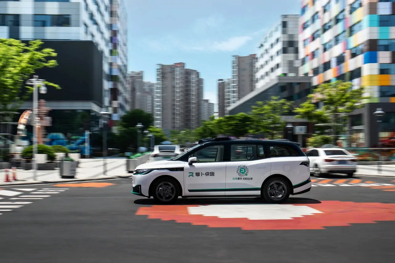 A Baidu Apollo Go autonomous robotaxi driving through a modern urban street in China
