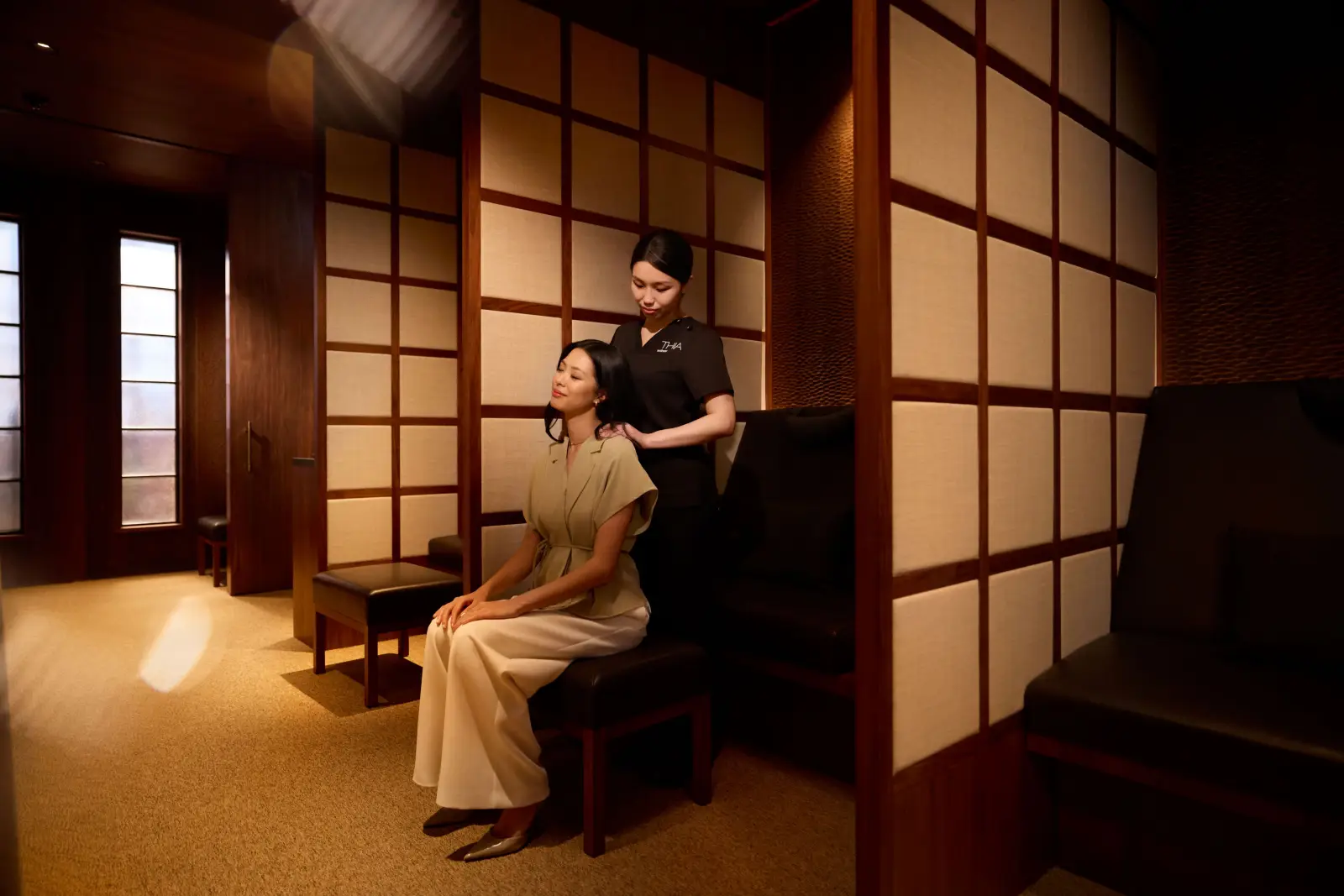 Passenger receiving shoulder massage in private wellness booth at Cathay Pacific Wing First lounge