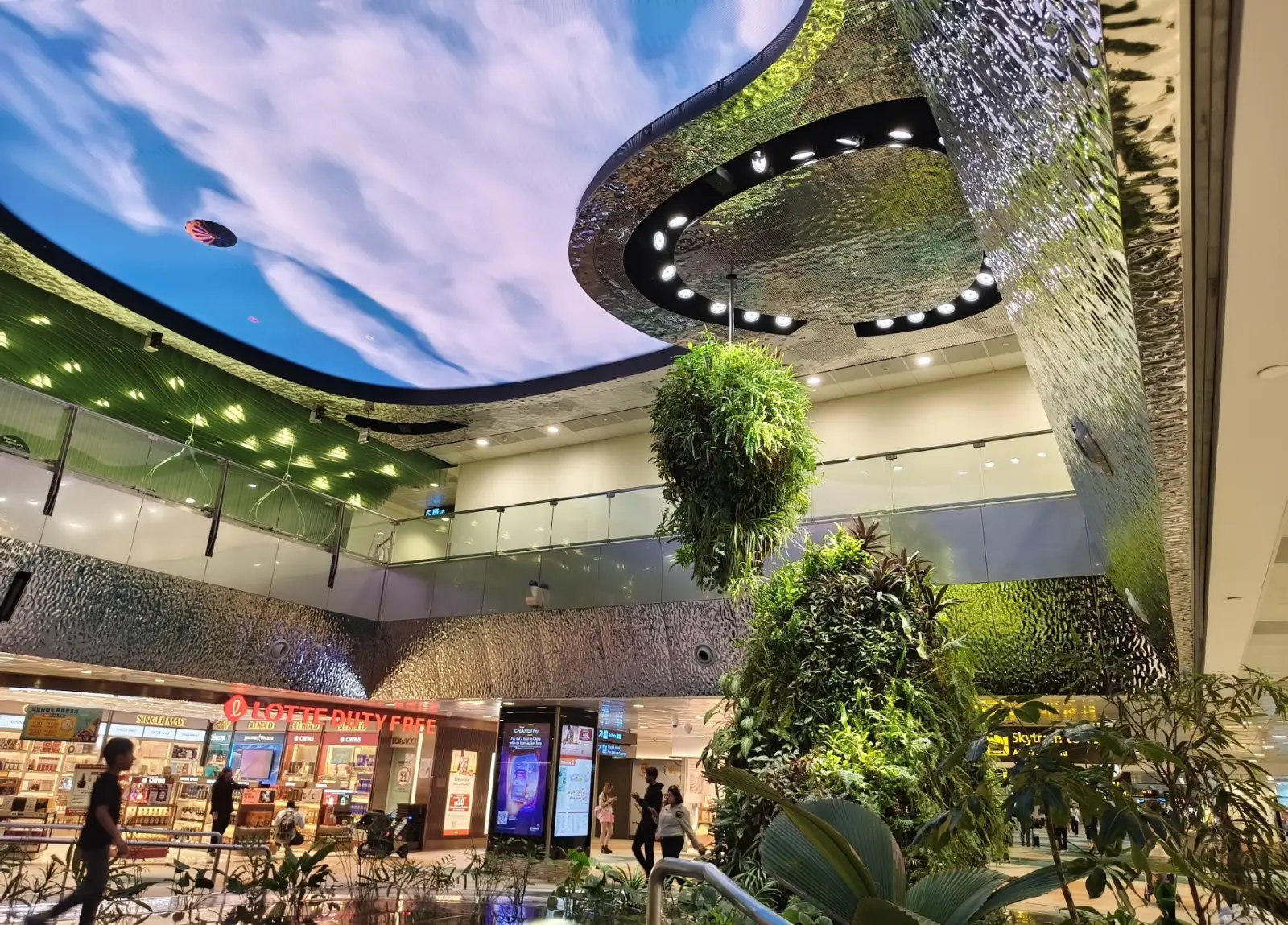 Interior of Singapore Changi Airport with indoor garden, digital ceiling and duty free shops