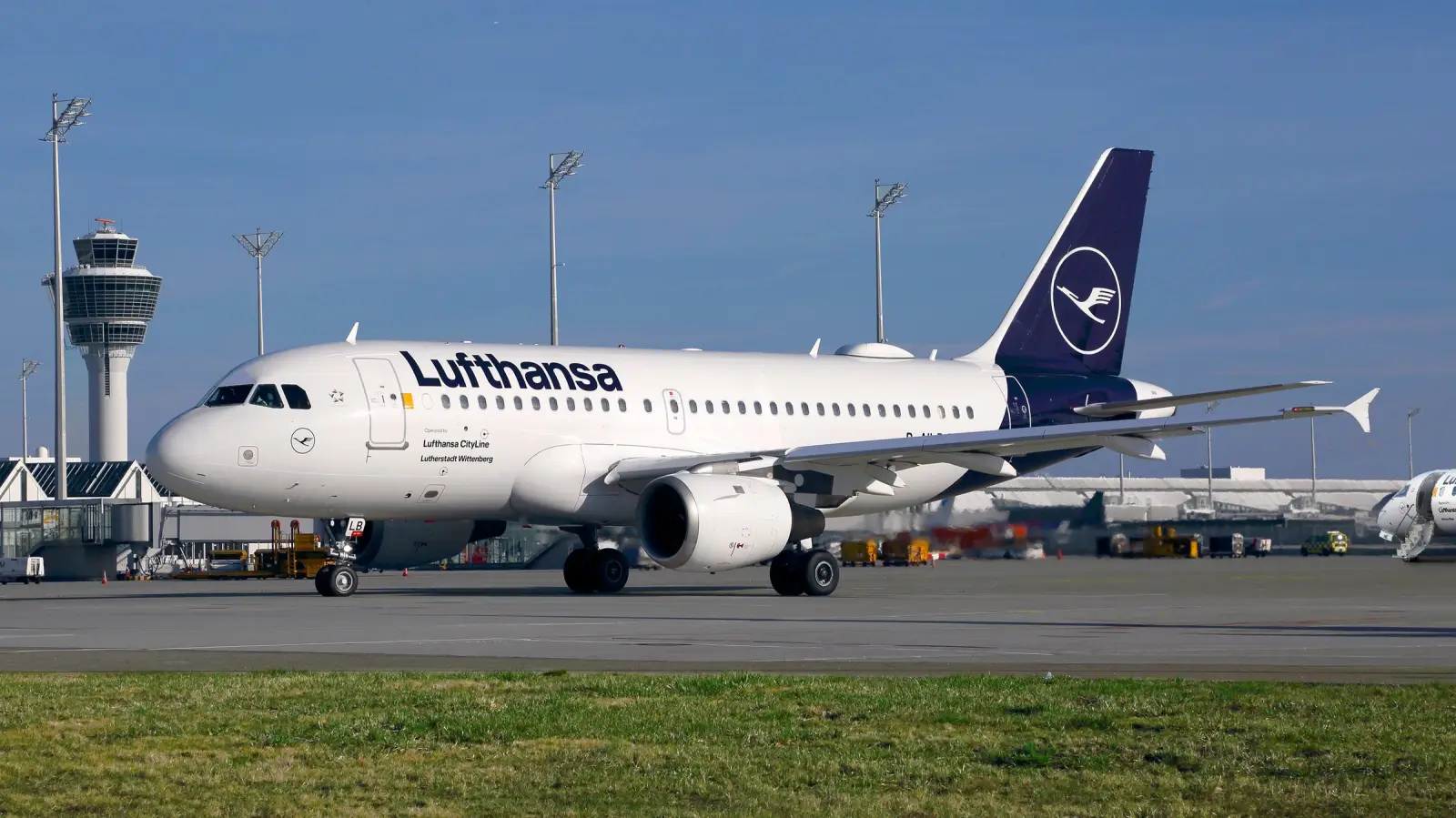 Lufthansa CityLine aircraft on airport tarmac near control tower as regional airline operations are suspended