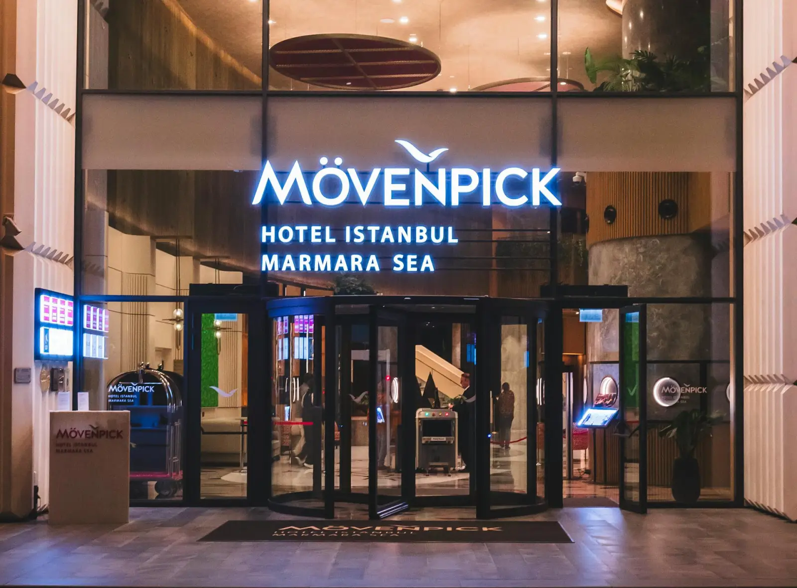 Mövenpick Hotel Istanbul Marmara Sea entrance with illuminated signage and revolving doors at night
