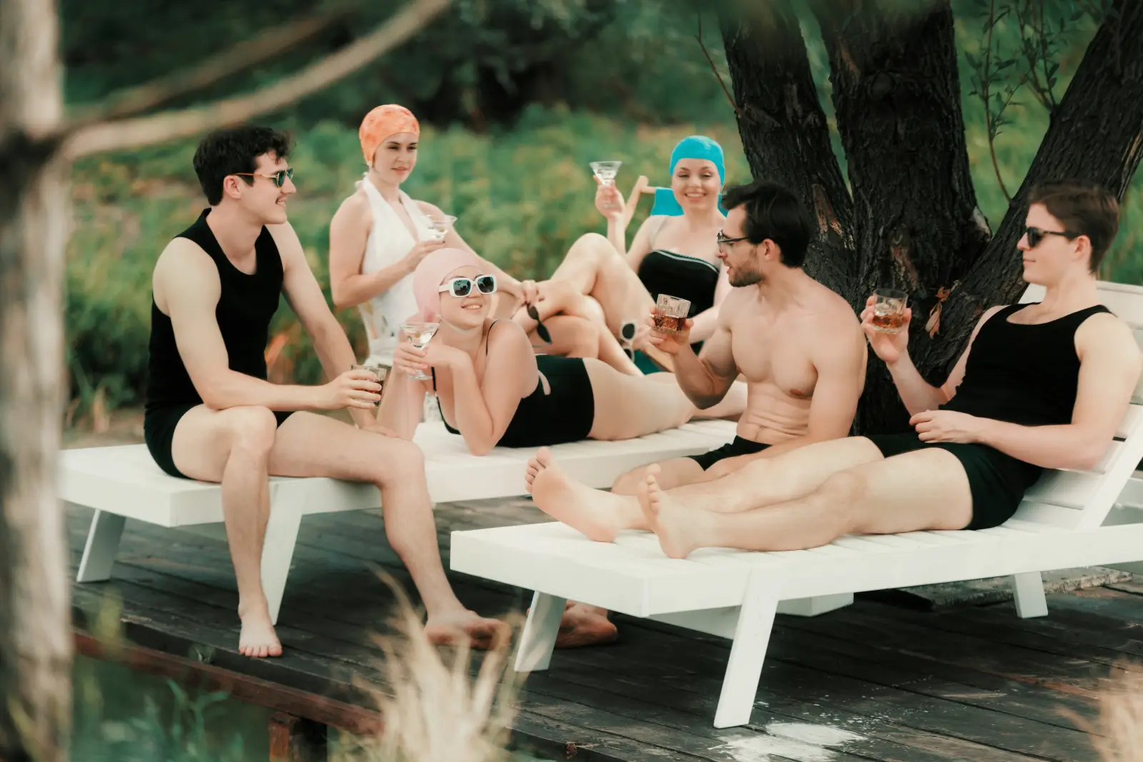 Retro style swimwear group relaxing outdoors with vintage accessories and sunglasses