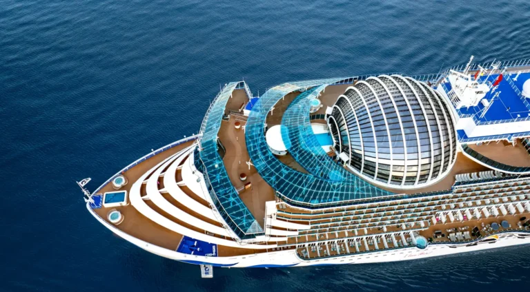 Aerial view of the Sun Princess cruise ship at sea, showcasing its modern glass dome and expansive deck areas