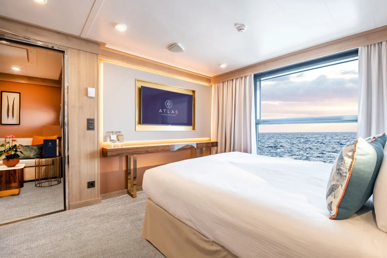 Atlas Ocean Voyages Introduces All-Suite Accommodation Across Its Fleet 3 Atlas Ocean Voyages deluxe horizon suite with ocean view bedroom and modern cruise ship interior