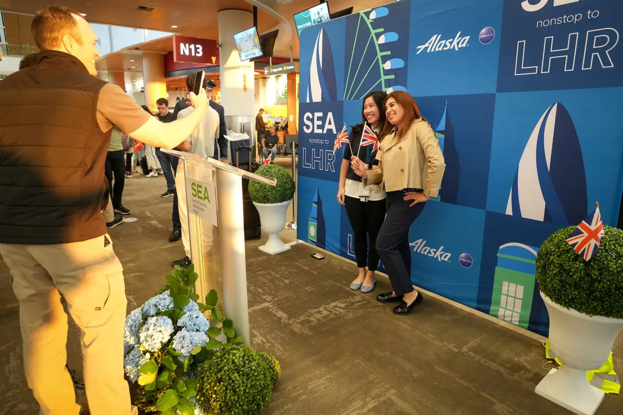Alaska Airlines Launches New European Routes To London And Reykjavík 3 Passengers pose at Alaska Airlines Seattle to London Heathrow inaugural flight gate
