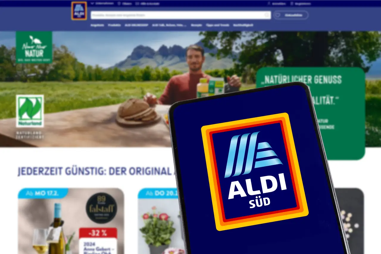 Aldi Süd logo on a smartphone screen in front of the retailer's website