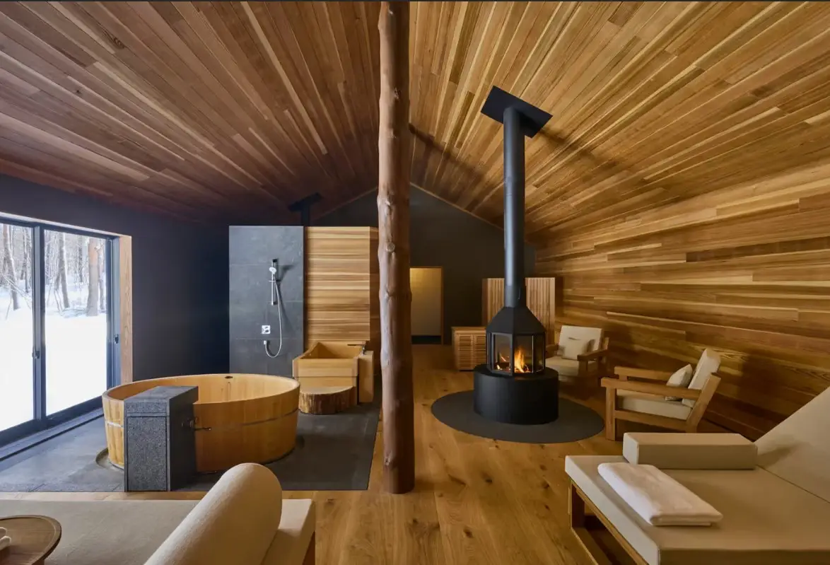 New Boutique Nature Retreat In Japan – Azuma Farm Koiwai - Focuses On Seasonal Farm Life 4 Luxury sauna pavilion at Azuma Farm Koiwai featuring wood interiors, private soaking tub and fireplace overlooking snowy forest scenery