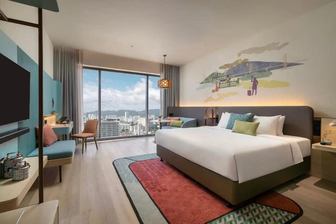 Bright, design-led guest room at Capri by Fraser Penang with city views and heritage-inspired wall mural