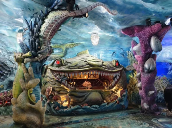 Surreal ocean-themed room inside Vietnam’s Crazy House in Da Lat featuring giant sea creatures, coral sculptures and a dramatic fish-shaped fireplace.