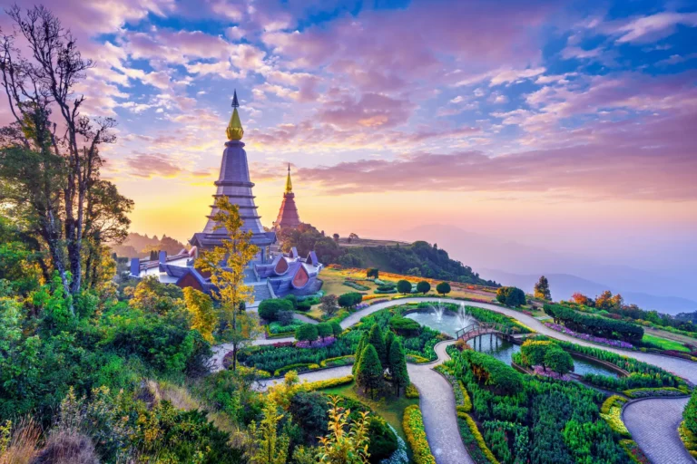 Twin pagodas and landscaped gardens at Doi Inthanon National Park in Chiang Mai, Thailand, during a colorful sunrise with mountain views.