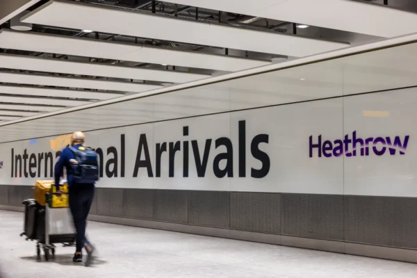 Passenger walks through Heathrow Airport international arrivals terminal in London amid falling passenger traffic.