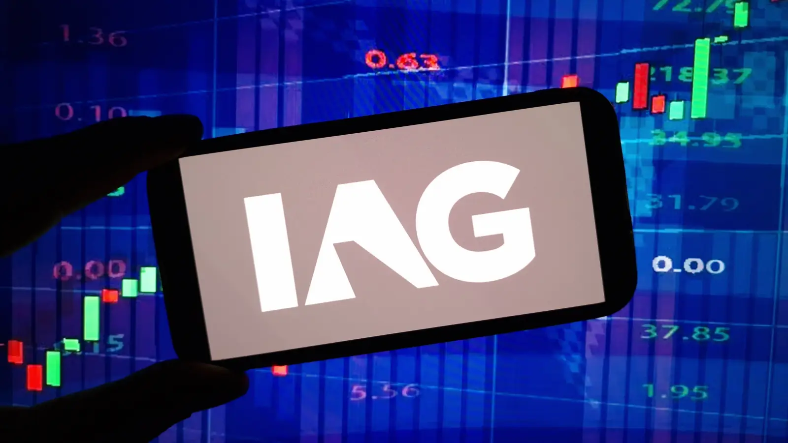 Smartphone displaying the IAG logo in front of a stock market chart as IAG shares rise after the airline group’s bond buyback announcement.
