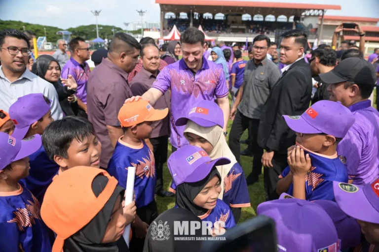 Mesut Özil interacts with children during a football clinic at Universiti Sains Malaysia in Penang, surrounded by young players and spectators
