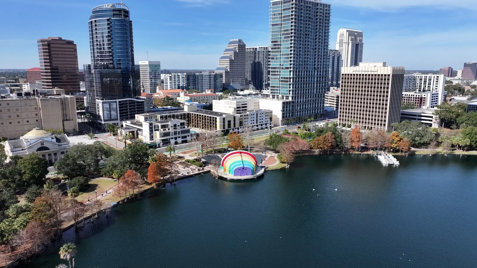 Aerial view of downtown Orlando, Florida, with modern skyscrapers overlooking Lake Eola on a sunny day.