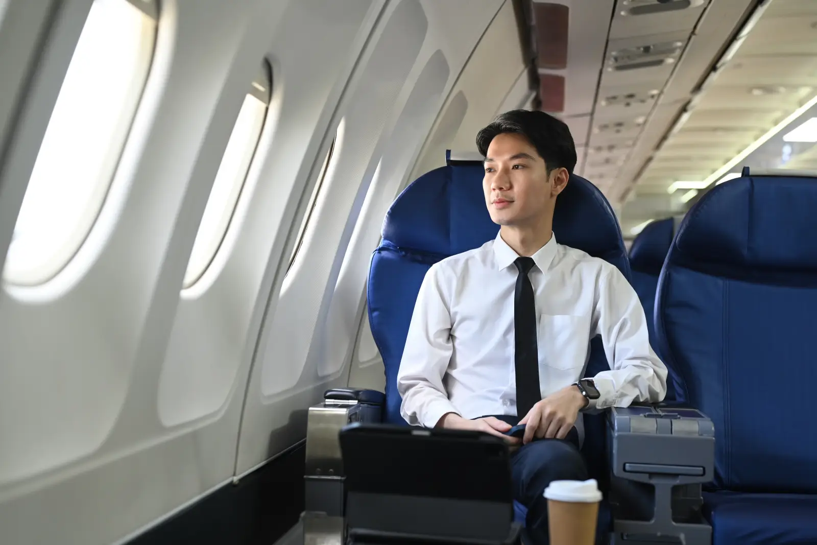 Southeast Asian business traveller sitting on an airplane during a work trip.