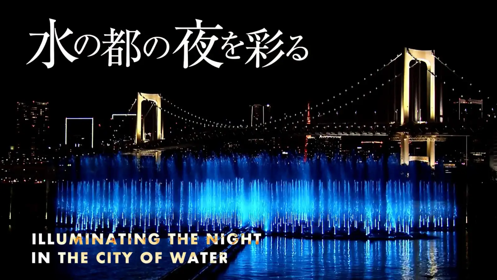 Tokyo Aqua Symphony fountain show in Odaiba at night with illuminated water jets and Rainbow Bridge in the background