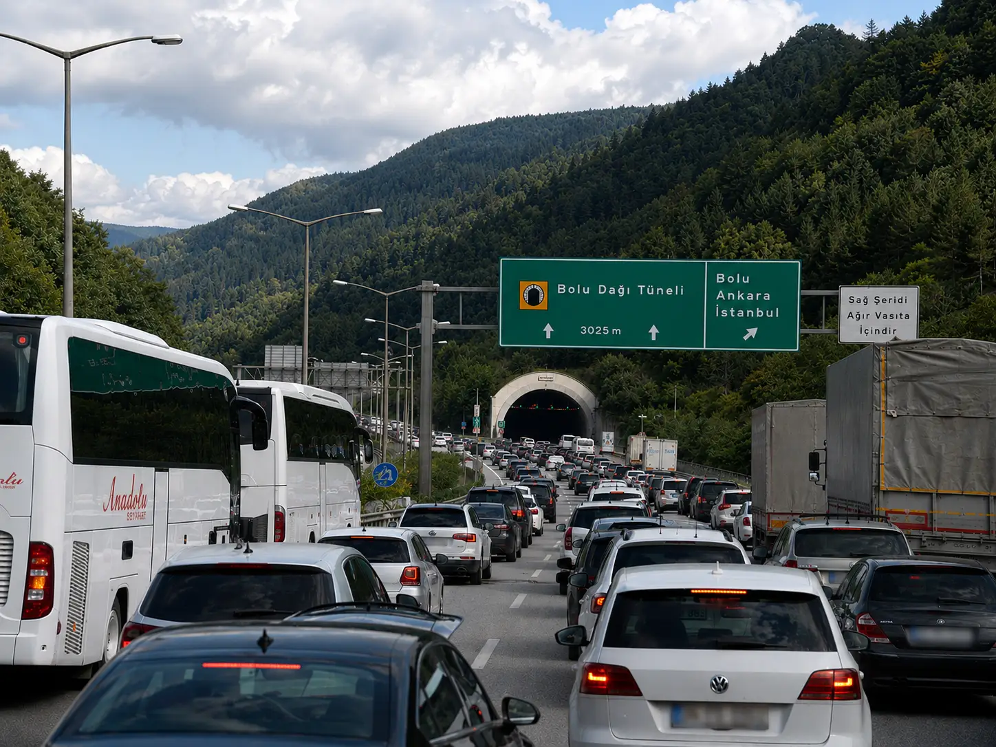 Heavy traffic on Turkey’s Anadolu Motorway near the Bolu Mountain Tunnel during the Eid holiday getaway, with long queues of cars, buses and trucks stretching through forested hills.