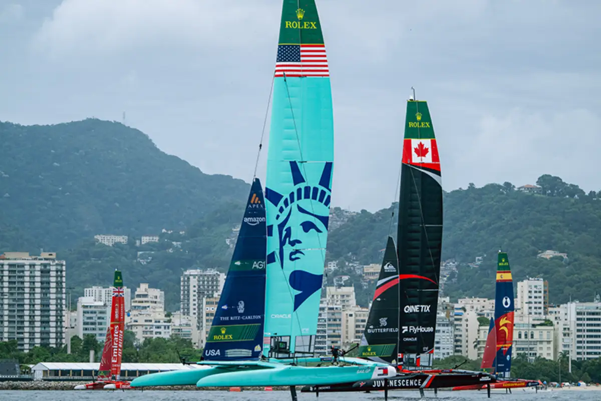 U.S. SailGP Team F50 catamaran racing during a SailGP event with New York skyline-inspired sail graphics and competing international teams in the background.