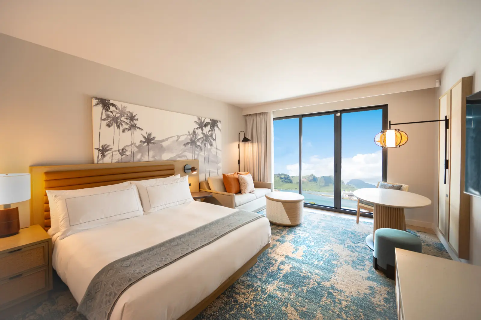 Modern ocean view guest room at Hale Hōkūala Kaua‘i with king bed and balcony overlooking lush Hawaiian scenery