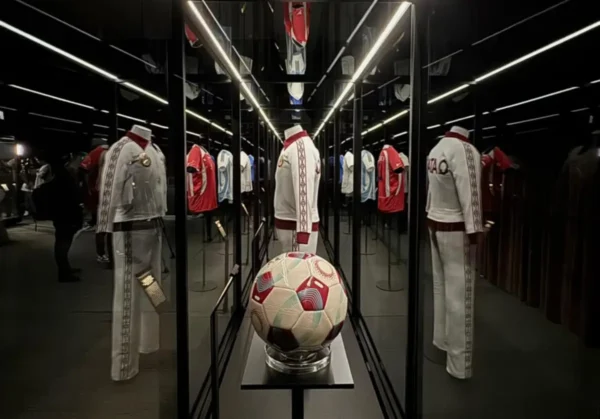 Football jerseys and a match ball on display in a mirrored gallery at the Objects of Glory exhibition at Museo Jumex in Mexico City