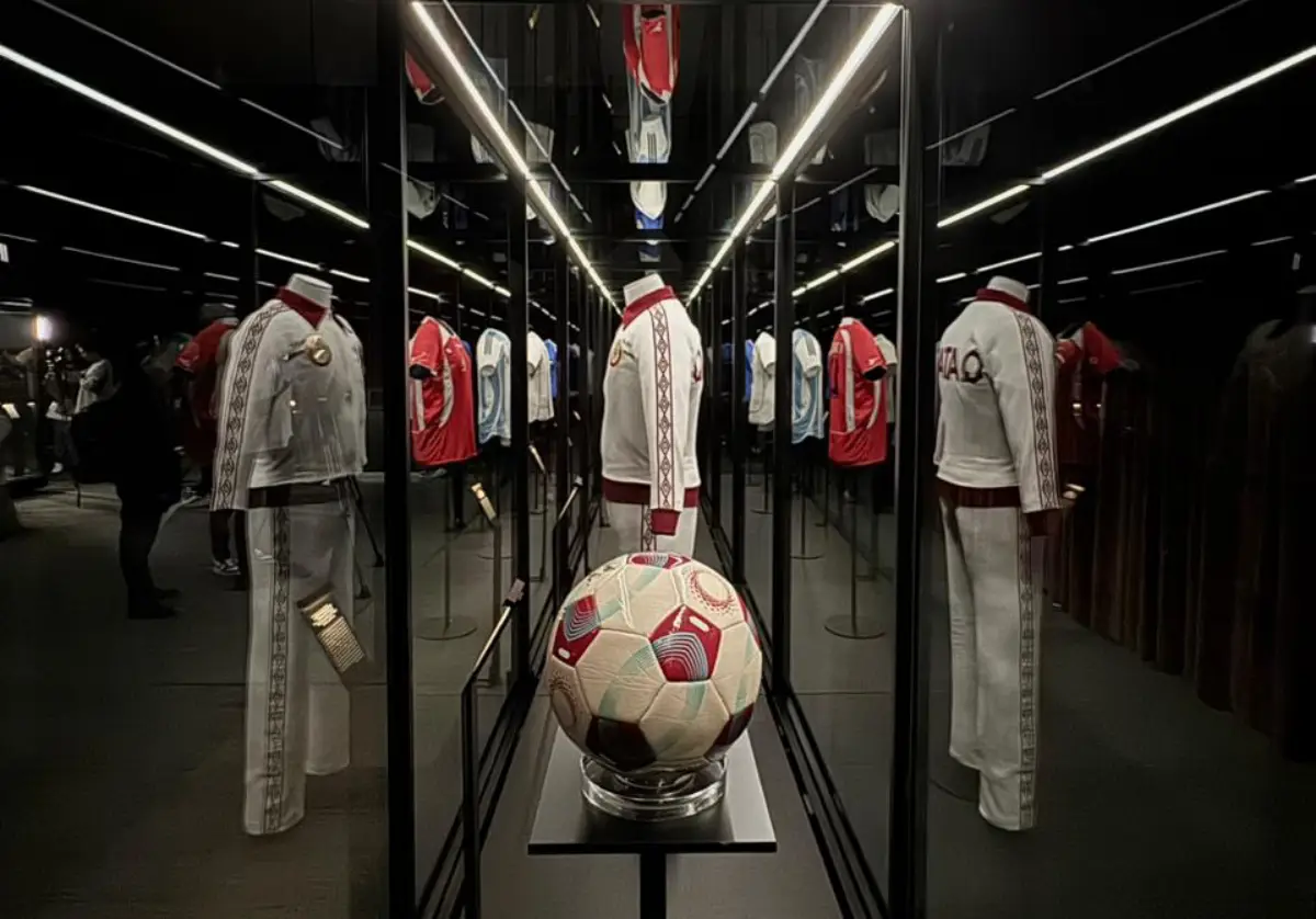 Football jerseys and a match ball on display in a mirrored gallery at the Objects of Glory exhibition at Museo Jumex in Mexico City