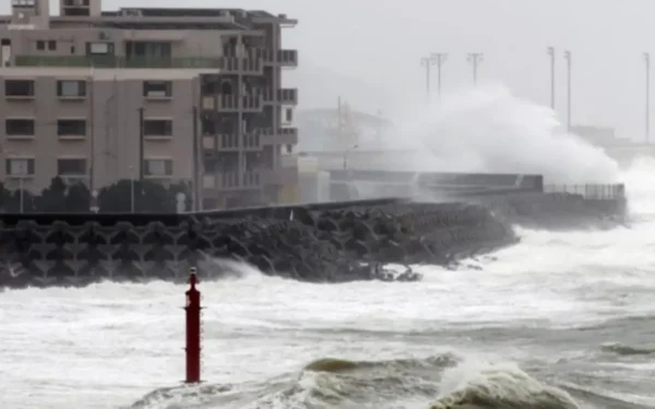 Storm waves crash against a coastal seawall in Japan during Tropical Storm Jangmi as rough seas hit the shoreline.