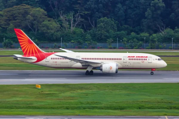 Home 7 An Air India Boeing 787-8 Dreamliner aircraft with registration VT-ANR taxiing on a runway, displaying the airline's red and cream livery with the iconic Konark Sun Wheel tail design