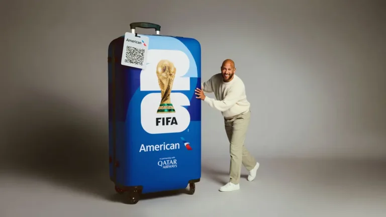 Former USMNT goalkeeper Tim Howard poses beside a giant American Airlines FIFA World Cup 26 branded suitcase during a promotional campaign shoot.