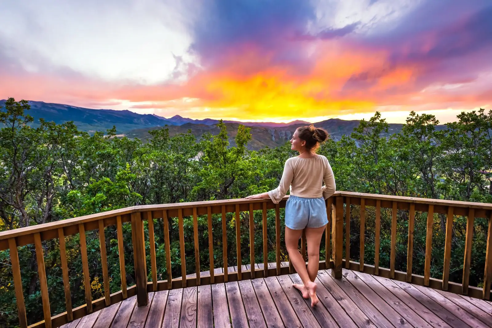 How To Spend Three Days In Colorado Without Rushing The Experience 5 Woman standing on a wooden deck overlooking Aspen, Colorado Rocky Mountains at sunset